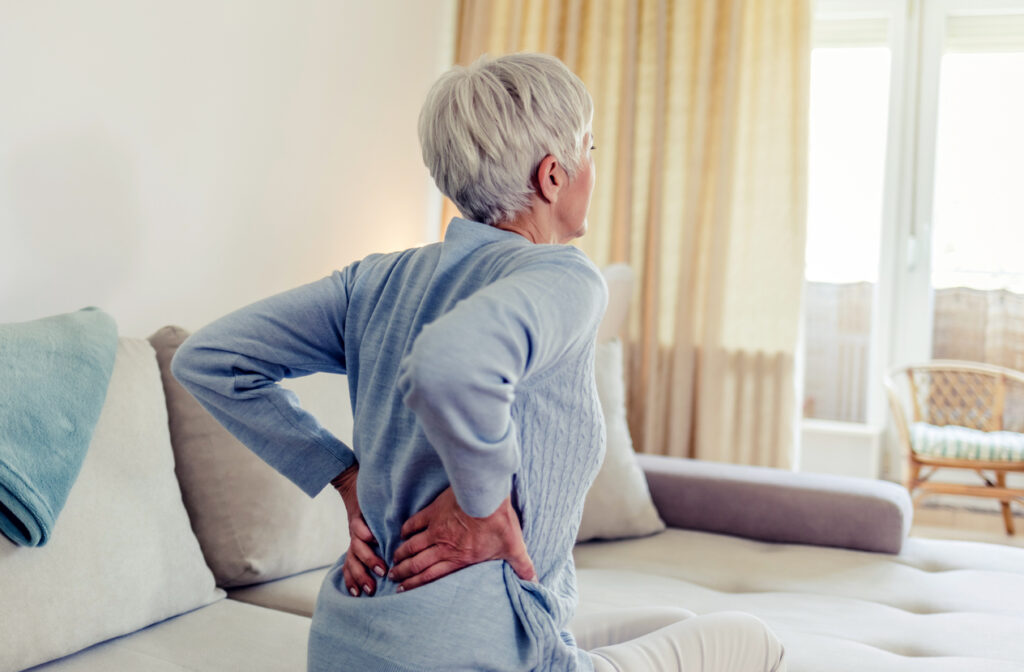 Woman feels back pain, massaging aching muscles