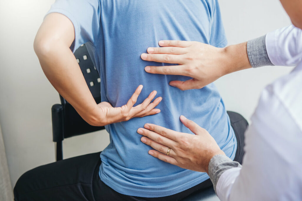 doctor checking left side back pain of a patient